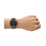 Reloj Fossil Machine con caja de acero plateado de 42mm y esfera negra con detalles en azul. Cuenta con pulsera de acero inoxidable plateado y subesferas de cronógrafo. Resistencia al agua de 5 ATM.