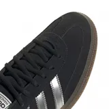 Championes Adidas Handball Spezial color negro con las tres tiras plateadas y suela marrón.