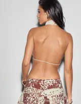 Top color amarillo pastel con cuello halter, espalda descubierta y lazos ajustables en el frente.