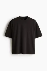 Remera negra de punto de algodón pesado, con cuello redondo ribeteado acanalado, hombros caídos y mangas cortas de corte holgado.