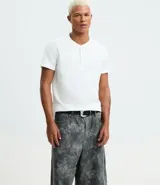 Remera masculina blanca de manga corta, con cuello redondo y abertura frontal con botones. Confeccionada en algodón y poliéster con textura, de corte ajustado.