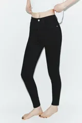 Jeans de tiro alto con corte skinny y largo tobillero. Presenta diseño clásico de cinco bolsillos, cierre frontal con cremallera y botón, con un acabado de lavado azul medio.