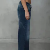 Pantalón jean de corte holgado en color azul con efecto deslavado y costuras decorativas en forma de estrella en la parte trasera.