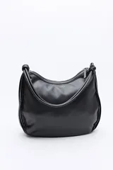 Cartera de hombro negra con diseño plisado vertical, asas largas con nudos decorativos y cierre de cremallera.