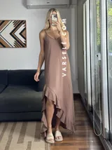 Vestido largo color marrón con breteles finos y volados asimétricos en el ruedo.