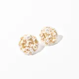 Aros tipo botón con base circular bordada con mostacillas, canutillos y perlas en tonos blanco, dorado y crema.