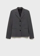 Chaqueta de corte recto estilo sastre, color gris, con cuello de solapa con muesca, cierre frontal de tres botones, bolsillos laterales de ribete y un bolsillo de ribete en el pecho. Cuenta con forro interior y mangas largas.