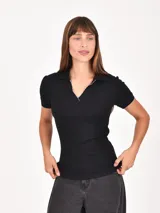 Remera negra de manga corta, con cuello polo y escote en V, y ribete blanco en el cuello y las mangas.