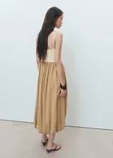 Vestido midi combinado con tirantes finos ajustables, escote recto y diseño con bajo abullonado estilo globo. Cuenta con cuerpo de punto en tono crudo y falda de tejido modal en tono tostado.