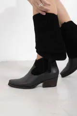 Botineta de cuero negro mate con inserciones de gamuza en el talón, punta cuadrada y tacón de bloque. Cuenta con cierre lateral interno.