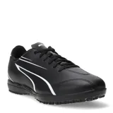 Championes de fútbol 5 Puma modelo Vitoria TT, color negro con detalles en blanco. Presentan una suela de goma con relieve para mayor tracción en canchas de césped sintético y cierre mediante cordones.