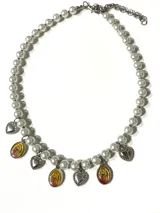 Collar de perlas de vidrio esmaltadas con dijes colgantes de corazones plateados y medallas ovaladas con imagen religiosa.