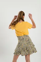 Minifalda con estampado animal print en tonos beige, negro y amarillo, con volados en el ruedo.