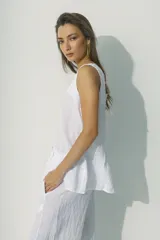 Blusa blanca sin mangas con escote en V y abertura frontal.