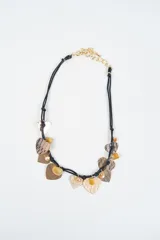 Collar de doble cordón negro con dijes colgantes en forma de corazón con texturas variadas y cuentas de piedra en tonos amarillos y dorados.