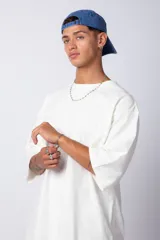 Remera de corte oversize, color blanco, con cuello redondo y mangas cortas amplias, confeccionada en algodón.