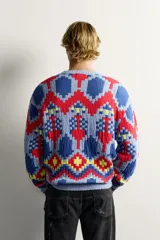 Jersey de punto tejido en hilatura de algodón, con diseño de patrones geométricos en colores celeste, azul, rojo y amarillo. Presenta cuello redondo, manga larga y acabados en rib.