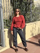 Blusa bordó con diseño fruncido mediante elásticos en el cuerpo y mangas largas abullonadas con puños elásticos.