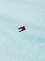 Chomba celeste Tommy Hilfiger de corte slim, con cuello clásico, cartera de dos botones y logo bordado en el pecho. Confeccionada en mezcla de algodón orgánico y elastano.