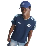 Remera de estilo urbano Adidas inspirada en la selección de fútbol de Alemania. Es de color azul marino con las icónicas tres tiras en celeste sobre los hombros y mangas. Presenta el logo del trébol de Adidas en blanco en el pecho derecho y el escudo de la federación alemana en el izquierdo.