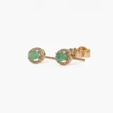 Aros tipo caravana de oro 18k con esmeralda central en corte ovalado rodeada por un halo de brillantes.