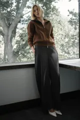 Chaqueta estilo bomber de lana bouclé color marrón, con cuello alto, cierre frontal con cremallera y puños y ruedo en tejido rib.