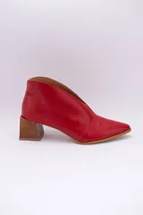 Botín de cuero rojo con tajo frontal, punta fina y taco cuadrado de madera.