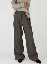Pantalon de vestir de corte sastrero y tiro alto, con pinzas frontales, cierre de doble botón y pernera ancha.