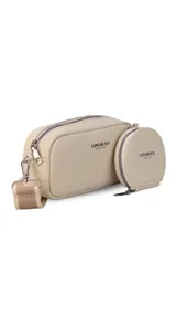 Bandolera compacta color beige, confeccionada en cuero sintético con textura granulada. Presenta un diseño de doble compartimento con cierre, incluyendo un monedero circular desmontable. Cuenta con correa ajustable y herrajes metálicos plateados.