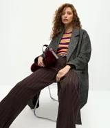 Pantalón de corte recto confeccionado en punto roma, con diseño de raya de tiza. Presenta cintura estructurada con trabillas para cinturón y bolsillos laterales.