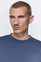 Remera de punto de algodón con corte oversized, cuello redondo acanalado y diseño de hombros caídos.