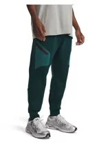 Pantalón de jogging Under Armour modelo Unstoppable Fleece, color verde oscuro, de corte ajustado en las piernas y tejido de doble punto elástico. Cuenta con cintura elástica con cordón interno, bolsillos laterales abiertos y un bolsillo lateral con cremallera.