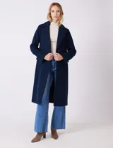 Tapado largo de lana marca Michael Kors, de corte recto y silueta estructurada. Presenta cuello solapa, cierre frontal con botones y bolsillos laterales con tapa. Incluye forro interno a tono.