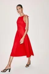 Vestido midi negro con cuello halter y falda acampanada con volumen.