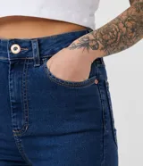 Pantalón skinny jeans azul oscuro con cintura alta, trabillas, cierre con botón y cremallera, bolsillos delanteros y traseros, y pespuntes en contraste. Confeccionado en tejido de jeans con 71% algodón, 26% poliéster y 3% elastano.