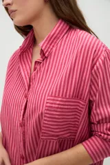 Camisa de manga larga de algodón, con diseño a rayas en tonos azules y morados, calce holgado, cuello camisero, cierre frontal con botones y un bolsillo aplicado en el pecho.
