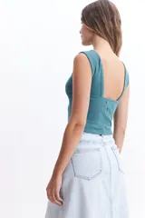 Musculosa cropped color verde azulado, de corte ajustado y espalda descubierta.