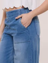 Jean pull on de tiro alto, color azul oscuro, con perneras amplias estilo wide leg, cintura elastizada en la espalda y bolsillos delanteros tipo parche con pespuntes contrastantes.