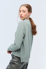 Sweater de tejido de punto color beige, con escote en V y calce holgado.