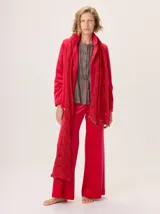 Bufanda larga de lana tejida a mano, color rojo vibrante, con diseño calado y textura gruesa.