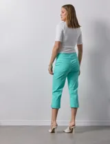 Pantalón capri blanco de gabardina elastizada. Pretina ancha elastizada, delantera con bolsillos simulados y trasera con bolsillos aplicados.