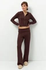 Camperita deportiva color marrón oscuro, ajustada al cuerpo, con capucha y cierre frontal a tono. Presenta costuras verticales que estilizan la figura.