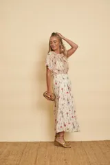 Pollera midi de algodón con estampado floral en tonos pasteles, diseño cruzado con pinzas y elástico en la parte posterior de la cintura.