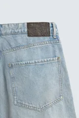 Bermudas de denim de algodón, color celeste claro con efecto vintage y manchas claras en las perneras. Tienen un corte ancho (baggy fit), tiro alto y cinco bolsillos.