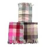 Bufanda rectangular de tejido afelpado con diseño de cuadros en tonos rosado, gris y beige. Presenta terminaciones con flecos en los extremos.