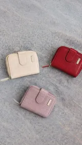 Billetera corta de símil cuero con textura croco, cierre perimetral y solapa con broche a presión. Cuenta con tarjeteros, visor, compartimento para billetes y bolsillo posterior con cierre.
