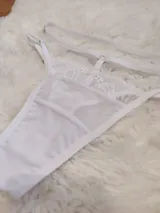 Pack de tres tangas tipo colaless confeccionadas en microtul y encaje, con tiras laterales regulables. El diseño presenta detalles de encaje en los bordes y transparencias.