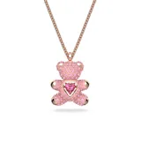 Colgante con dije de osito tridimensional cubierto de cristales rosados en técnica Pointiage®, con un cristal central en forma de corazón suspendido que se mueve con la luz. Cuenta con una cadena de eslabones con baño en tono oro rosa.