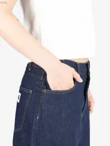 Pantalón de denim de corte holgado y pierna recta, con cintura regular y cierre de cremallera. Presenta costuras en contraste y un diseño de estilo relajado.