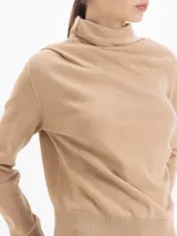 Sweater de lana merino color negro, con cuello medio alto y detalle de frunces en los hombros que aportan volumen. De calce regular y tejido suave.
